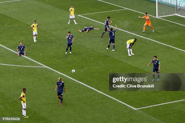 Colombia players look dejected as the Japan players celebrate following their sides victory in the 2018 FIFA World Cup Russia group H match between...