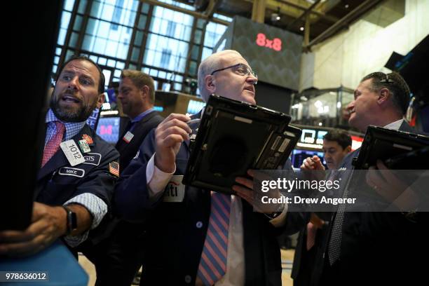 Traders and financial professionals work ahead of the opening bell on the floor of the New York Stock Exchange , June 19, 2018 in New York City. U.S....