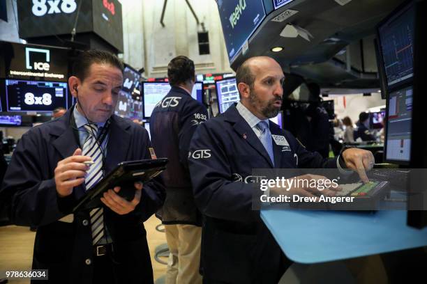 Traders and financial professionals work ahead of the opening bell on the floor of the New York Stock Exchange , June 19, 2018 in New York City. U.S....