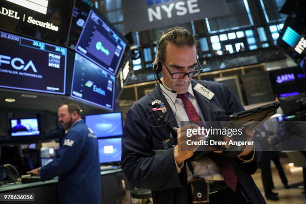 Traders and financial professionals work ahead of the opening bell on the floor of the New York Stock Exchange , June 19, 2018 in New York City. U.S....