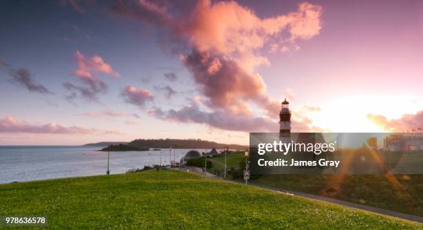 sunset over lighthouse, plymouth, uk - plymouth england fotografías e imágenes de stock