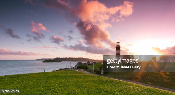 sunset over lighthouse, plymouth, uk - lighthouse sunset stock pictures, royalty-free photos & images