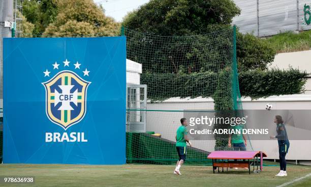 To R, Brazil's goalkeeper Ederson, Brazil's goalkeeper Alisson and Brazil's goalkeeper Cassio pass the ball over a table-tennis table to Brazil's...