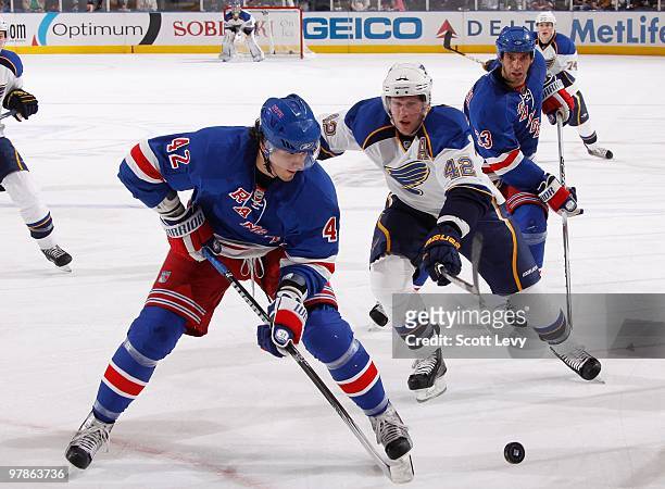 Artem Anisimov of the New York Rangers skates with the puck against David Bakes of the St. Louis Blues on March 18, 2010 at Madison Square Garden in...