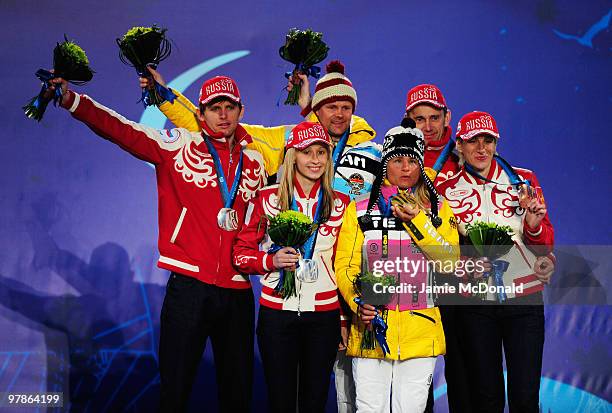 Gold medalists Verena Bentele of Germany and guide Thomas Friedrich celebrate with silver medalists Mikhalina Lysova of Russia and guide Alexey...