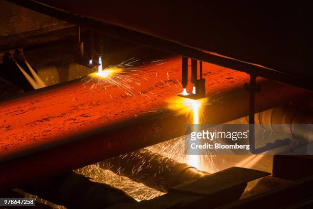 Cutting torches cut measured lengths of hot steel slabs as they emerge from the continuous casting machine in the converter shop at the Novolipetsk...