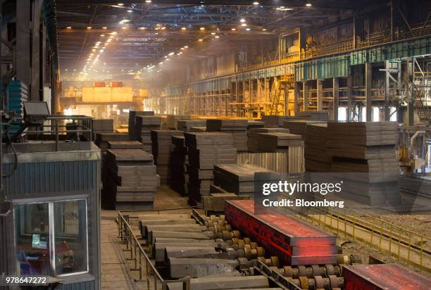 Cooling steel slabs move along a conveyor system in a storage area in the converter shop at the Novolipetsk Steel PJSC plant, operated by NLMK Group,...