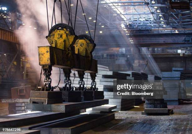 Large magnetic lift moves steel slabs around the storage area in the converter shop at the Novolipetsk Steel PJSC plant, operated by NLMK Group, in...