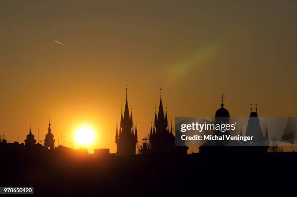 silhouettes of buildings of old town in prague against sky at sunrise, czech republic - teynkirche stock-fotos und bilder