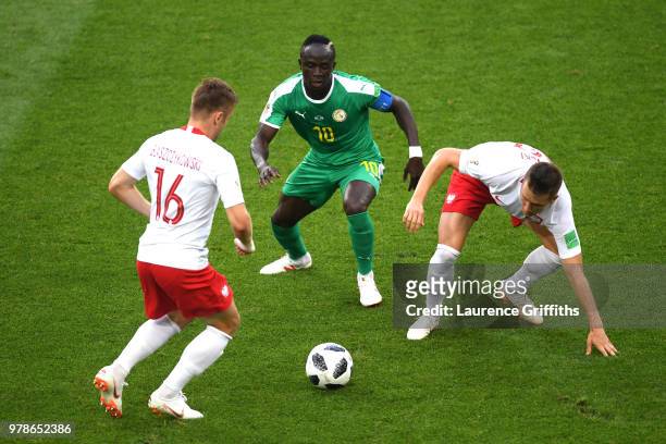 Sadio Mane of Senegal challenge for the ball with Jakub Blaszczykowski and Piotr Zielinski of Poland during the 2018 FIFA World Cup Russia group H...