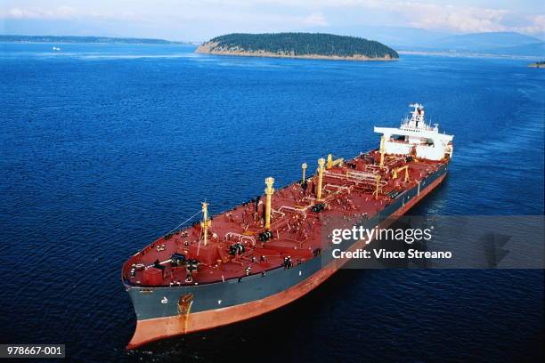 tanker anchored offshore, land in background - olietanker stockfoto's en -beelden
