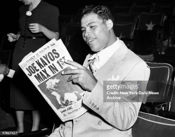 Day after Joe Louis versus Max Schmeling II fight. The usually immobile countenance of the champ yields to a smile as Joe reads some highly...