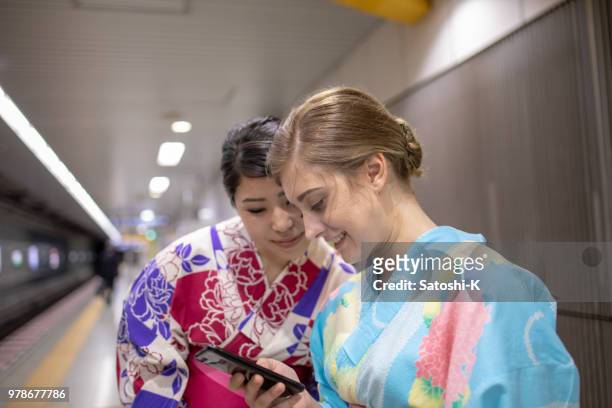 multi-ethinic group of friends watching smart phone screen together - yukata stock pictures, royalty-free photos & images