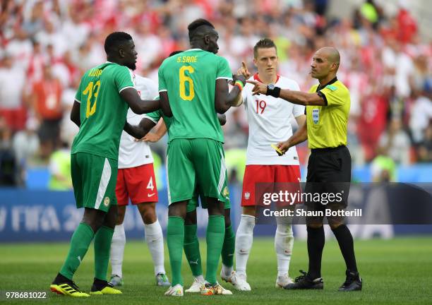 Salif Sane of Senegal is booked by Referee Nawaf Shukralla during the 2018 FIFA World Cup Russia group H match between Poland and Senegal at Spartak...