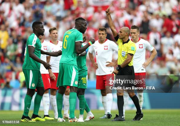 Salif Sane of Senegal is booked by Referee Nawaf Shukralla during the 2018 FIFA World Cup Russia group H match between Poland and Senegal at Spartak...