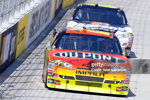 Jeff Gordon drives the DuPont Chevrolet ahead of David Reutimann, driver of the Aaron's Dream Machine Toyota during practice for the NASCAR Sprint...