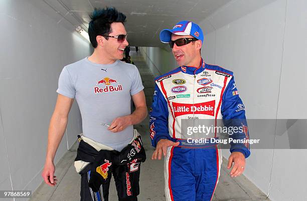 Scott Speed , driver of the Red Bull Toyota, talks with Marcos Ambrose, driver of the Little Debbie Toyota, in the garage area after practice for the...