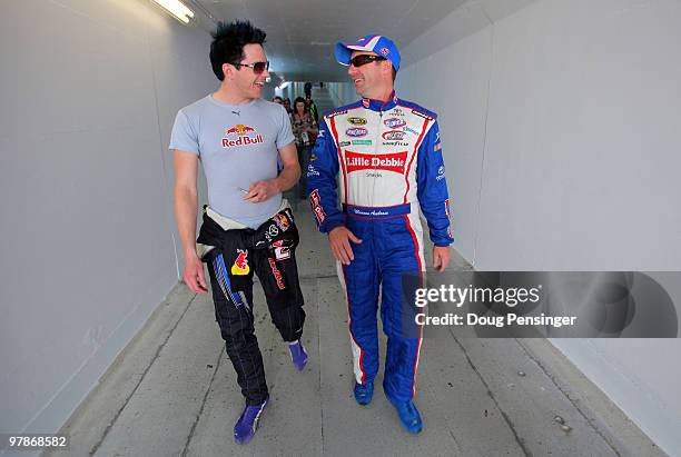 Scott Speed , driver of the Red Bull Toyota, talks with Marcos Ambrose, driver of the Little Debbie Toyota, in the garage area after practice for the...