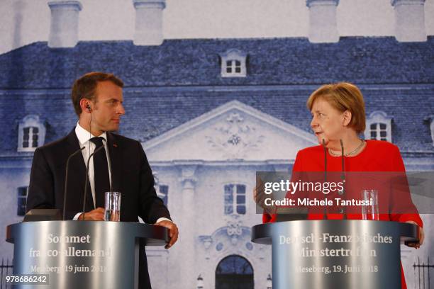 German Chancellor Angela Merkel and French President Emmanuel Macron address the media during a joint press conference at Schloss Meseberg...