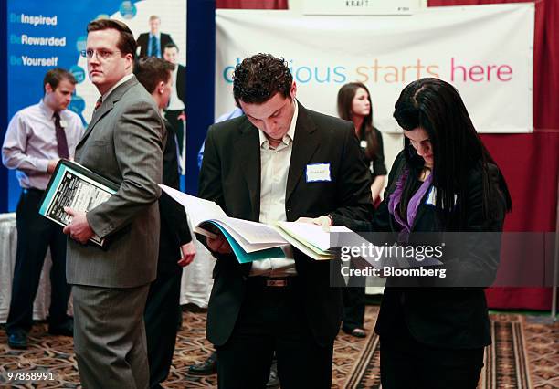 Ahmad Bazzoun, center left, and Sonya Abbiss plan which employers to visit at Eastern Michigan University's collegiate job fair in Livonia, Michigan,...