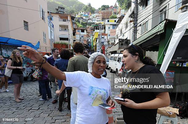 An unidentified resident of Dona Martha shantytown in Rio de Janeiro, Brazil, asks a member of a human rights defense organization about their new...
