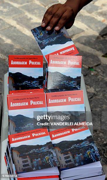 An unidentified resident of Dona Martha shantytown in Rio de Janeiro, Brazil, picks up from a member of a human rights defense organization a copy of...