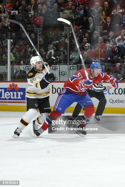 Benoit Pouliot of the Montreal Canadiens skates for positions in front of Mark Stuart of Boston Bruins during the NHL game on March 13, 2010 at the...