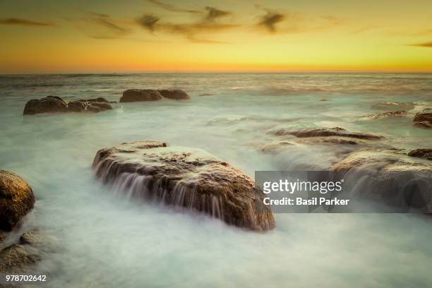rock formations in south atlantic ocean at sunset, cape town, western cape province, south africa - rocky parker stock pictures, royalty-free photos & images
