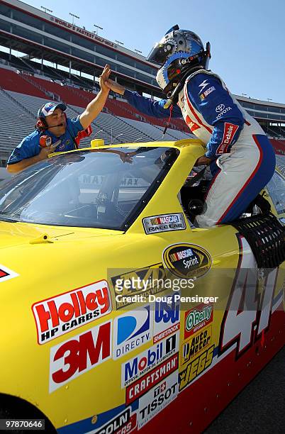 Marcos Ambrose , driver of the Little Debbie Toyota, high fives a crew member as he gets out of his car after qualifying for the NASCAR Sprint Cup...