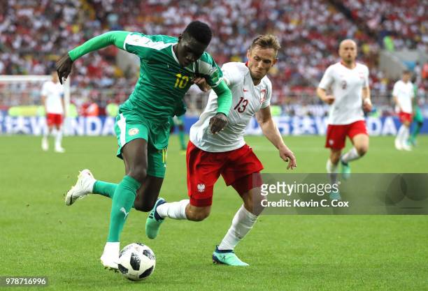 Ismaila Sarr of Senegal is challenged by Maciej Rybus of Poland during the 2018 FIFA World Cup Russia group H match between Poland and Senegal at...
