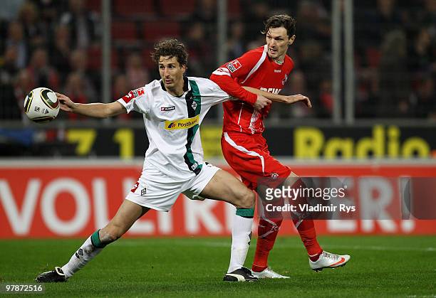 Milivoje Novakovic of Koeln and Roel Brouwers of Moenchengladbach battle for the ball during the Bundesliga match between 1. FC Koeln and Borussia...