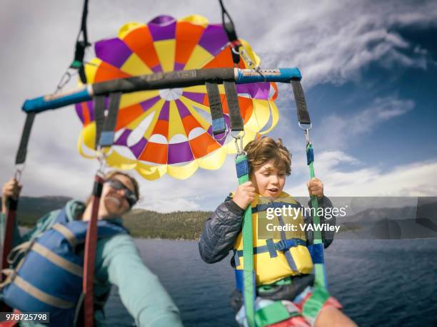 mother and 9 year old son parasail over beautiful lake tahoe, california in early summer - parasailing stock pictures, royalty-free photos & images