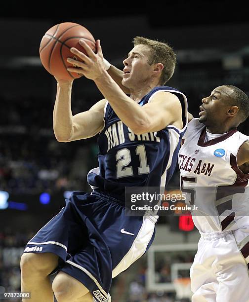 Jared Quayle of the Utah State Aggies shoots against Dash Harris of the Texas A&M Aggies during the first round of the 2010 NCAA men's basketball...