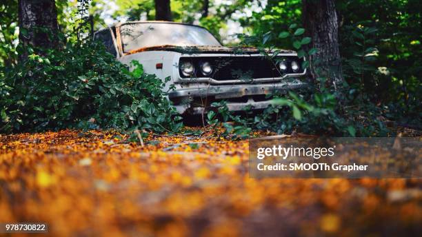 rusty abandoned car in forest, thailand - abandoned car - fotografias e filmes do acervo