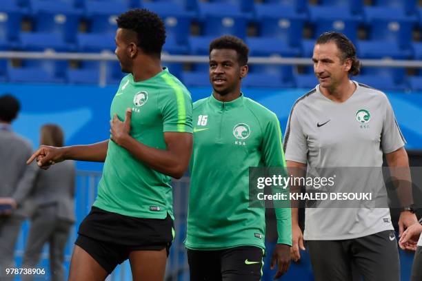 Saudi Arabia's coach Juan Antonio Pizzi watches as defender Ali Al-Bulaihi and midfielder Abdullah Alkhaibari arrive for a training session at the...