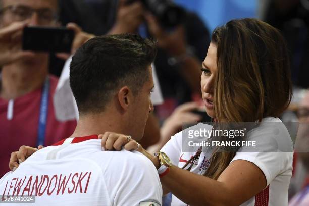 Poland's forward Robert Lewandowski is comforted by his wife Anna Lewandowska at the end the Russia 2018 World Cup Group H football match between...