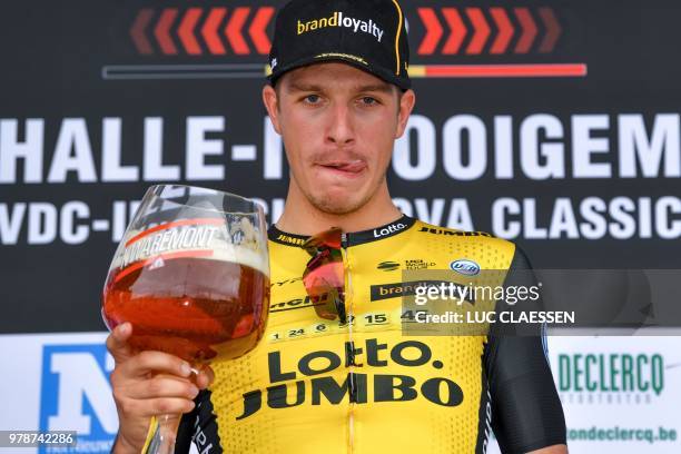 Winner Dutch Danny van Poppel of Team LottoNL-Jumbo licks his lips after tasting a celebratory beer on the podium after the Halle-Ingooigem cycling...