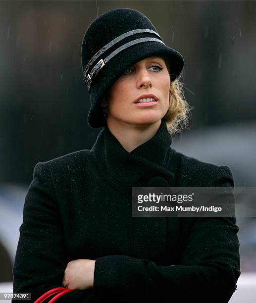 Zara Phillips gets caught in a rain shower whilst watching the Cheltenham Gold Cup contenders parade prior to the race on day 4 of the Cheltenham...