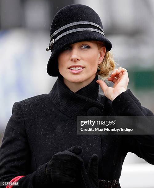 Zara Phillips gets caught in a rain shower whilst watching the Cheltenham Gold Cup contenders parade prior to the race on day 4 of the Cheltenham...