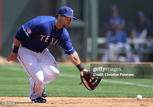 Infielder Chris Davis of the Texas Rangers fields a ground ball out against the Cleveland Indians during the MLB spring training game at Surprise...