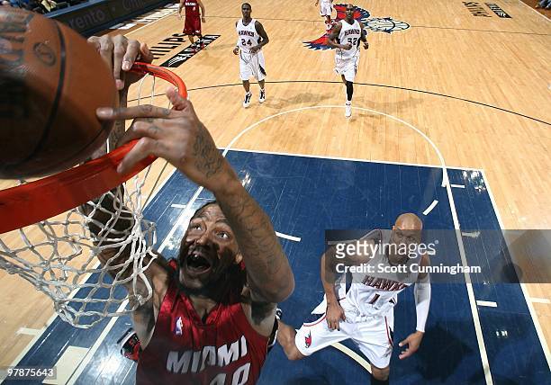 Udonis Haslem of the Miami Heat dunks against Maurice Evans of the Atlanta Hawks during the game at Philips Arena on February 10, 2010 in Atlanta,...