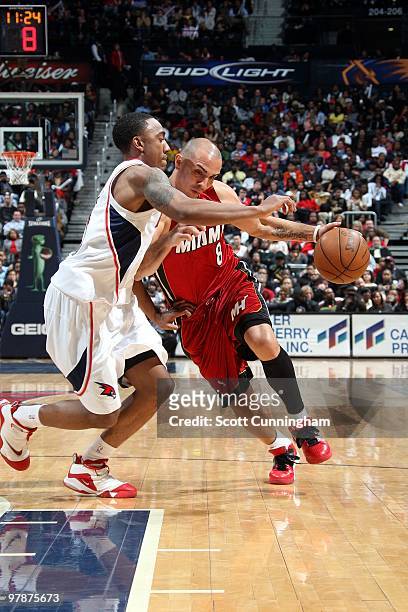 Carlos Arroyo of the Miami Heat drives to the basket against Jeff Teague of the Atlanta Hawks during the game at Philips Arena on February 10, 2010...