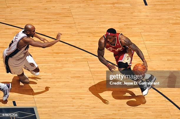 LeBron James of the Cleveland Cavaliers drives to the basket against Trenton Hassell of the New Jersey Nets during the game at the IZOD Center on...