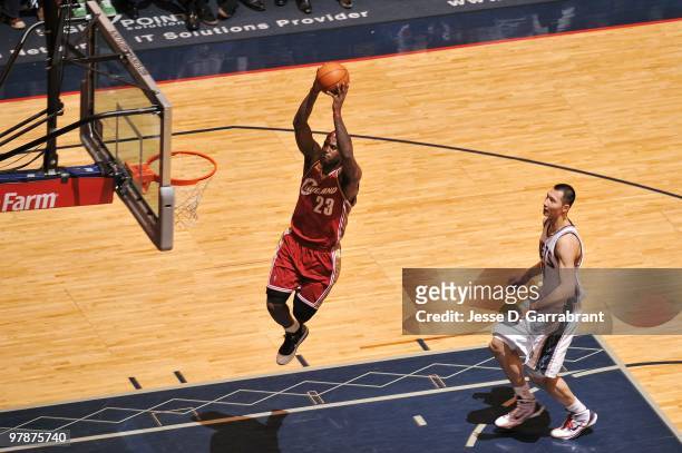 LeBron James of the Cleveland Cavaliers dunks against Yi Jianlian of the New Jersey Nets during the game at the IZOD Center on March 03, 2010 in East...