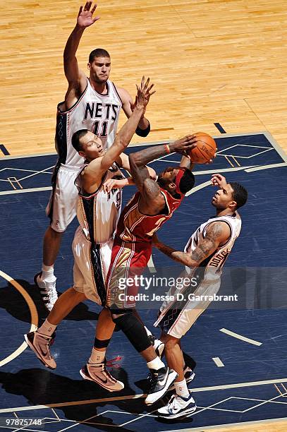 LeBron James of the Cleveland Cavaliers goes up for a shot against Yi Jianlian, Chris Douglas-Roberts and Brook Lopez of the New Jersey Nets during...