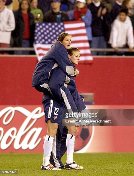 United States defender Brandi Chastain, who is injured, celebrates with a piggy-back ride from forward Cinbdy Parlow October 1, 2003 at Gillette...
