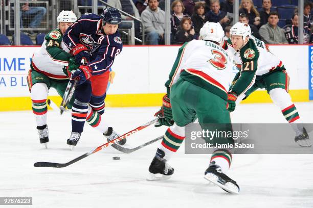 Umberger of the Columbus Blue Jackets attempts to shoot the puck past Cam Barker, Marek Zidlicky, and Kyle Brodziak, all of the Minnesota Wild during...