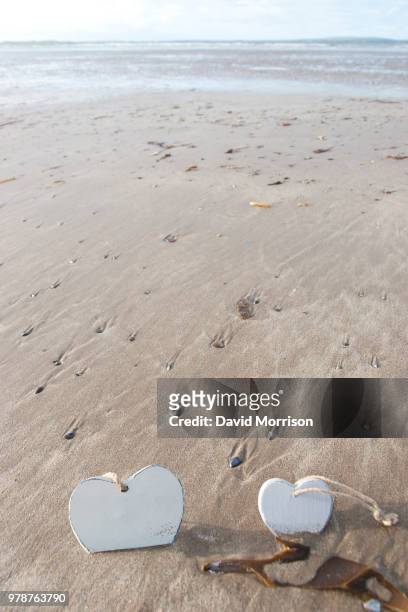 two wooden love hearts in the sand - david concha fotografías e imágenes de stock