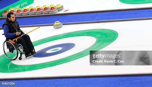 Egidio Marchese of Italy helps his teammate line up a stone during the Wheelchair Curling Tie-breaker game between Italy and Sweden on day eight of...