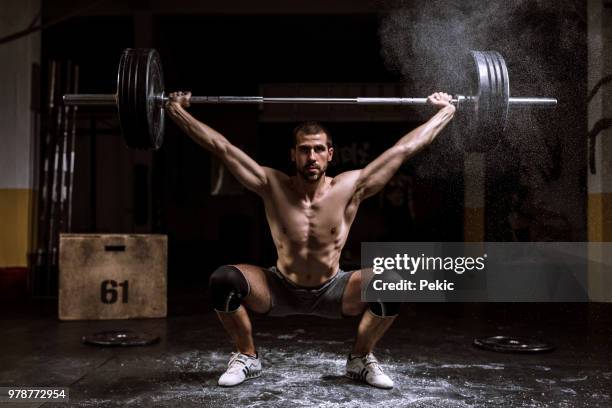 handsome young bodybuilder lifting weights - power lifting stock pictures, royalty-free photos & images